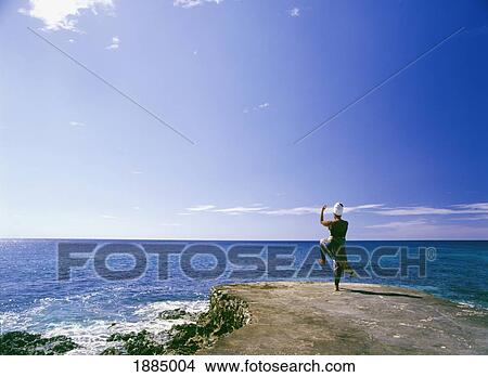 Picture - Woman Practicing Tai Chi By The Ocean. Fotosearch