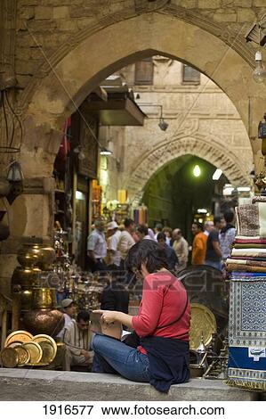 Woman Reading Guidebook Beside Stalls View Large Photo Image Stock Photo - Woman Reading Guidebook Beside Stalls. Fotosearch
