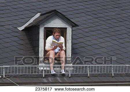 Woman reading in a window of a mansard roof, Mainz, Germany View Large Photo Image Stock Photo - Woman reading in a window of a mansard roof, Mainz, Germany. Fotosearch