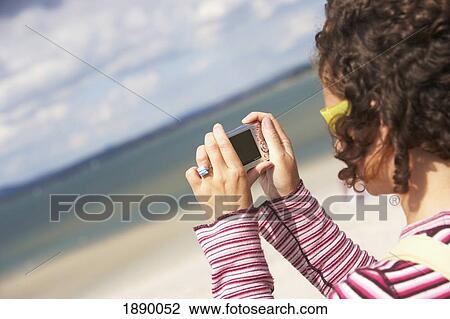 Stock Image - Woman Reading On Beach. Fotosearch