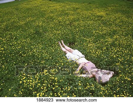 Stock Image - Woman Relaxing In Field Of Buttercups With The Cirque De Gavarnie In The Background. Fotosearch