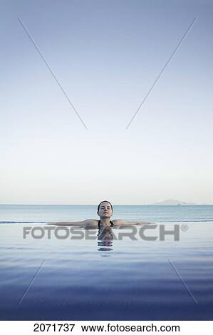 Stock Photo - Woman Relaxing In Infinity Pool, Panama City, Panama. Fotosearch