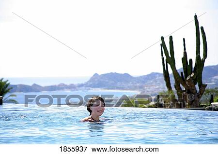 Stock Photo - Woman Relaxing In Pool, Cabo San Lucas, Mexico. Fotosearch
