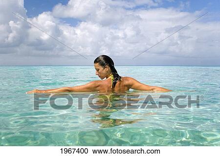 Stock Image - Woman Relaxing In Tropical Ocean Water.. Fotosearch