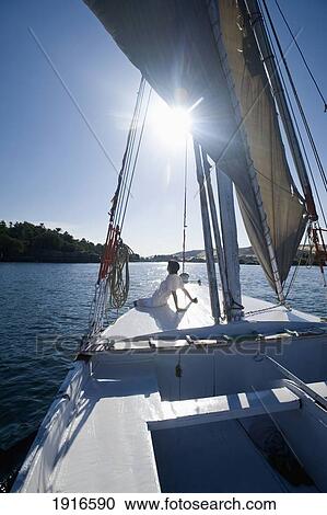 Stock Image - Woman Relaxing On Deck Of Felucca Going Down The River Nile. Fotosearch