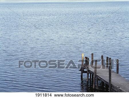 Picture - Woman Resting On End Of Pier Beside Derwent Water, Lake District, Uk.. Fotosearch