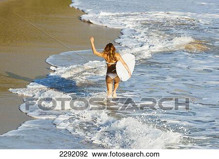 Woman running along beach with surfboard; Tarifa, Cadiz Province, Andalusia, Spain View Large Photo Image Stock Image - Woman running along beach with surfboard; Tarifa, Cadiz Province, Andalusia, Spain. Fotosearch