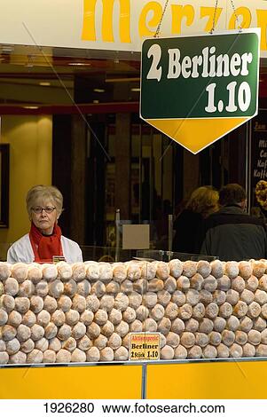 Stock Image - Woman Selling Doughnuts, Cologne, Germany. Fotosearch