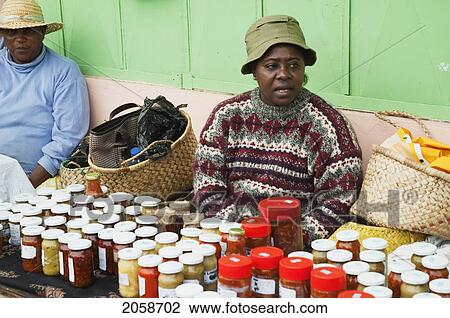 Stock Image - Woman Selling Preserves And Bottled Pickles For Sale, Port Mathurin, Rodrigues Island, Mauritius. Fotosearch