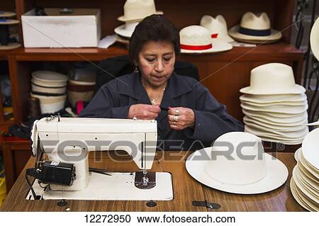 Stock Image - Woman sewing the black brim on to a panama hat at the Barranco Panama Hat Factory, Cuenca, Azuay, Ecuador. Fotosearch