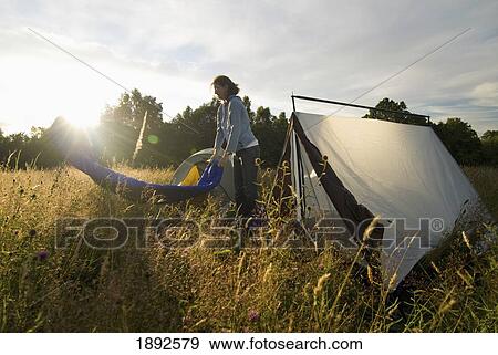 Woman Shaking Out Sleeping Bag Beside Tent In Meadow, Sunset View Large Photo Image Stock Photo - Woman Shaking Out Sleeping Bag Beside Tent In Meadow, Sunset. Fotosearch