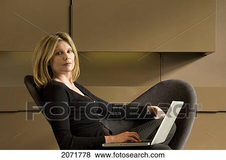 Woman Sitting In A Chair On A Laptop, Toronto, Ontario View Large Photo Image Stock Photo - Woman Sitting In A Chair On A Laptop, Toronto, Ontario. Fotosearch