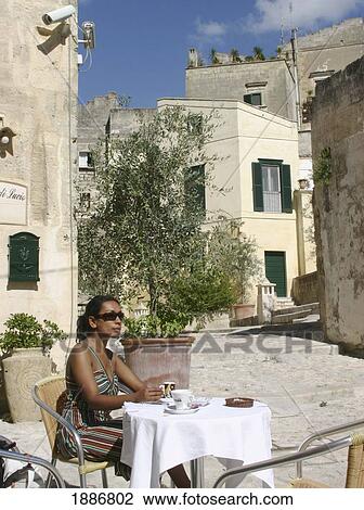 Stock Image - Woman Sitting In Alfresco Cafe. Fotosearch