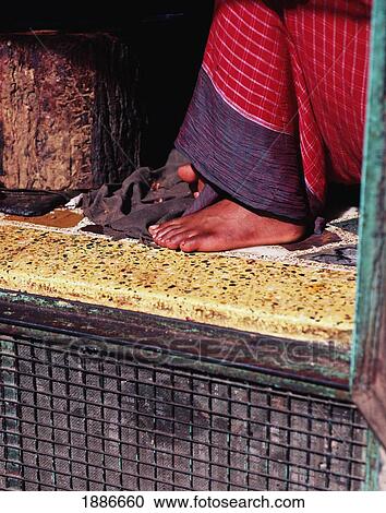 Stock Image - Woman Sitting In Doorway, Close Up. Fotosearch