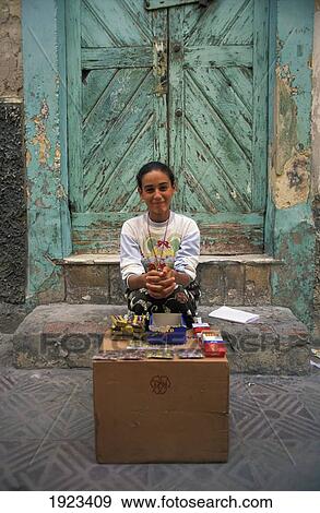 Stock Photo - Woman Sitting In Front Of Old Door, Old Medina. Fotosearch