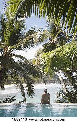 Woman Sitting On Edge Of Infinity Pool Overlooking Coastline View Large Photo Image Stock Image - Woman Sitting On Edge Of Infinity Pool Overlooking Coastline. Fotosearch