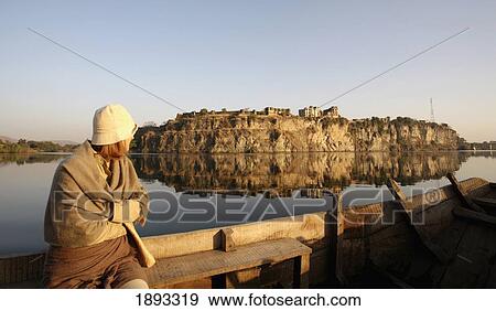 Stock Photo - Woman Sitting On Fence Looking At Bhainsrorgarh Fort. Fotosearch