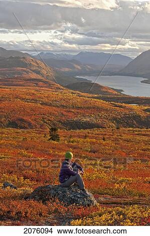 Woman Sitting On Rock Near Fish Lake; Whitehorse Yukon Canada View Large Photo Image Picture - Woman Sitting On Rock Near Fish Lake; Whitehorse Yukon Canada. Fotosearch