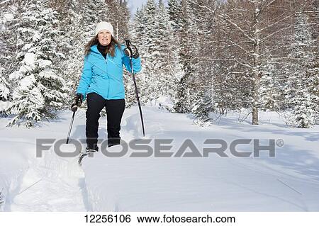 Woman snowshoes through a snow covered forest in winter; Ontario, Canada View Large Photo Image Stock Photograph - Woman snowshoes through a snow covered forest in winter; Ontario, Canada. Fotosearch