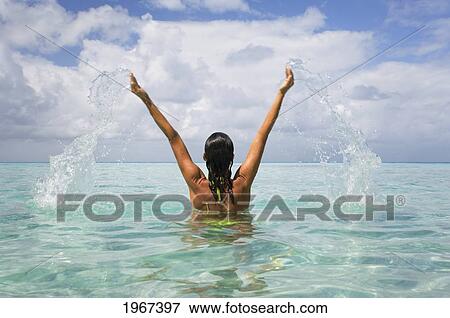 Stock Photo - Woman Splashing In Tropical Ocean Water.. Fotosearch