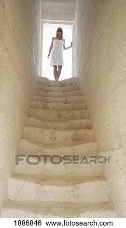 Stock Photograph - Woman Standing At Top Of Stairs. Fotosearch