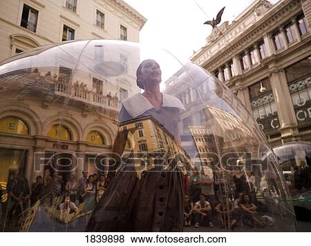 Stock Photo - Woman Standing Inside Transparent Glass Globe And Crowd Watching Her Performance; Rome, Italy. Fotosearch