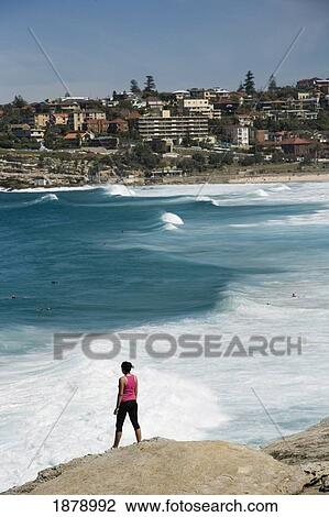 Woman Standing On Rock Over Looking Mackensies And Tamarama Bay, Near Bondi Beach View Large Photo Image Stock Image - Woman Standing On Rock Over Looking Mackensies And Tamarama Bay, Near Bondi Beach. Fotosearch