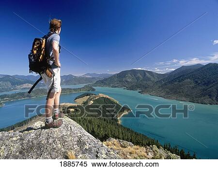Stock Photography - Woman Standing On Top Of Boulder And Enjoying The View. Fotosearch
