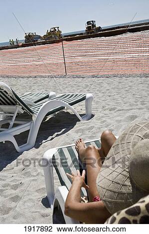 Woman Sunbathing At Lido Beach, With Sand Dredging In Background View Large Photo Image Stock Image - Woman Sunbathing At Lido Beach, With Sand Dredging In Background. Fotosearch