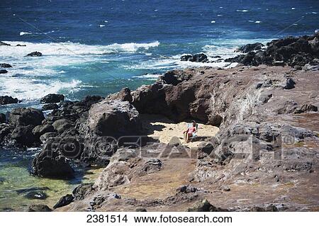Picture - Woman sunbathing in a secluded piece of beach at Ho'okipa Beach Park; Paia, Maui, Hawaii, United States of America. Fotosearch