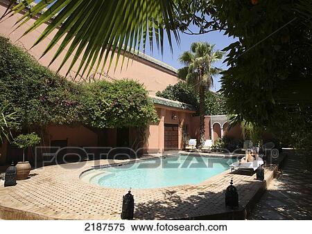 Stock Photography - Woman sunbathing in riad garden; Marrakesh, Morocco. Fotosearch
