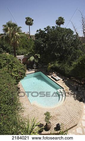 Stock Image - WOMAN SUNBATHING IN RIAD GARDEN&#xA; MARRAKESH MOROCCO. Fotosearch