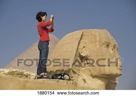 Picture - Woman Taking Photograph In Front Of Sphinx And Pyramid. Fotosearch