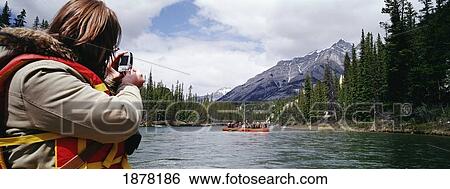 Stock Photograph - Woman Taking Picture Of Raft Tour Group. Fotosearch