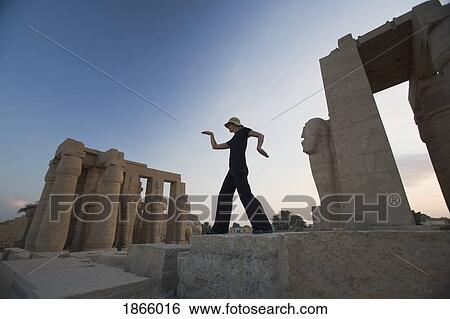 Stock Photograph - Woman Tourist Walks Like An Egyptian At The Ramesseum, Luxor, Nile Valley, Egypt. Fotosearch