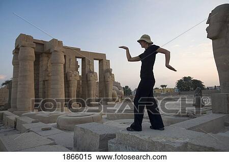 Stock Photography - Woman Tourist Walks Like An Egyptian At The Ramesseum, Luxor, Nile Valley; Luxor, Nile Valley, Egypt. Fotosearch