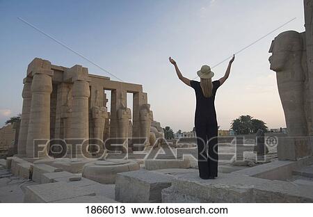 Stock Image - Woman Tourist With Arms Raised At The Ramesseum; Egypt, Africa. Fotosearch