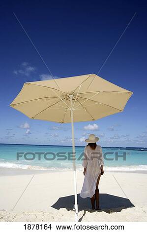 Picture - Woman Under Umbrella On Beach. Fotosearch