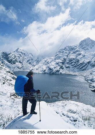 Stock Photography - Woman Walker Admiring View From The Routeburn Track In The Snow Near The Top Of The Harris Pass. Fotosearch