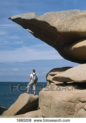 Woman Walker Standing Beside Rock Formation By Sea View Large Photo Image Stock Photo - Woman Walker Standing Beside Rock Formation By Sea. Fotosearch