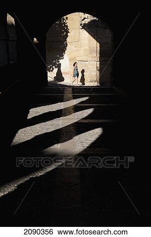 Woman Walking Against The Shadow Of Arches On The Main Square In Elciego, Basque Country, Spain View Large Photo Image Stock Photograph - Woman Walking Against The Shadow Of Arches On The Main Square In Elciego, Basque Country, Spain. Fotosearch