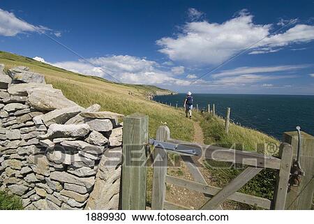 Woman Walking Along Coastal Path By Stone Wall View Large Photo Image Stock Image - Woman Walking Along Coastal Path By Stone Wall. Fotosearch