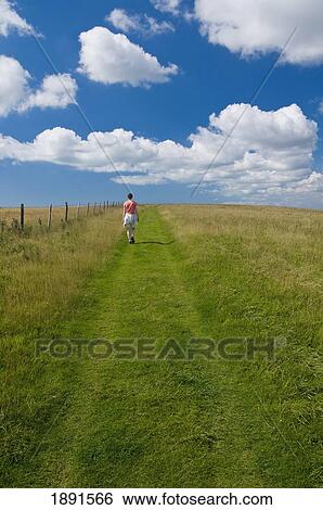 Woman Walking Along Track Through South Downs Between Lewes And Brighton View Large Photo Image Stock Photograph - Woman Walking Along Track Through South Downs Between Lewes And Brighton. Fotosearch