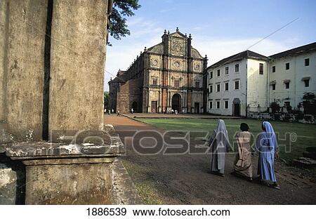 Stock Photo - Woman Walking Alongside Two Nuns In Front Of Churches In Goa. Fotosearch