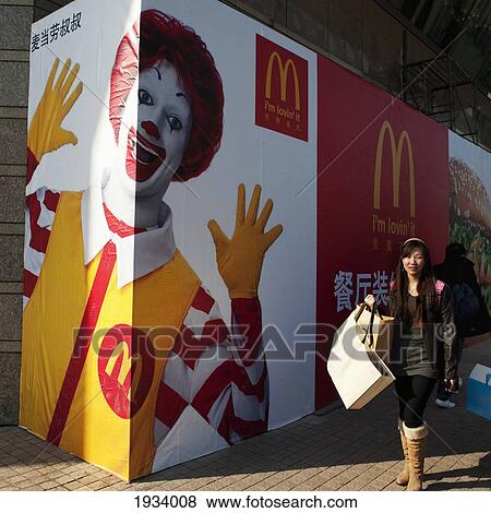 Stock Photo - Woman Walking By Mcdonald's Advertisement; Beijing, China. Fotosearch