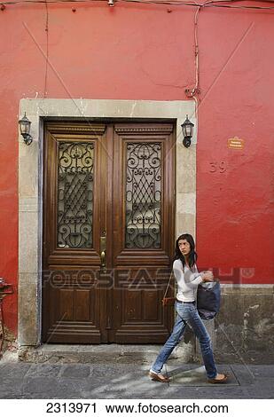 Woman walking by old door; Guanajuato, Guanajuato, Mexico View Large Photo Image Stock Image - Woman walking by old door; Guanajuato, Guanajuato, Mexico. Fotosearch