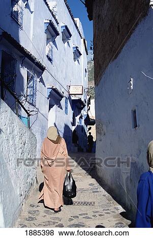 Stock Photo - Woman Walking Down Alley, Chaouen. Fotosearch