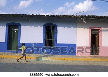 Stock Image - Woman Walking Down The Street In Jalcomulco. Fotosearch