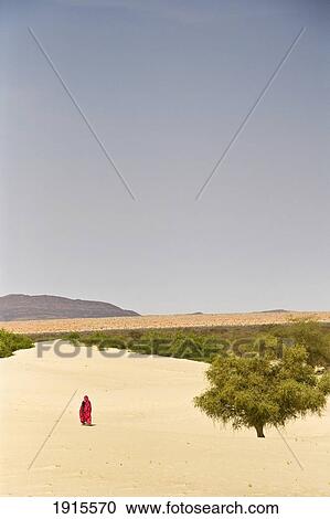 Stock Image - Woman Walking In Desert. Fotosearch