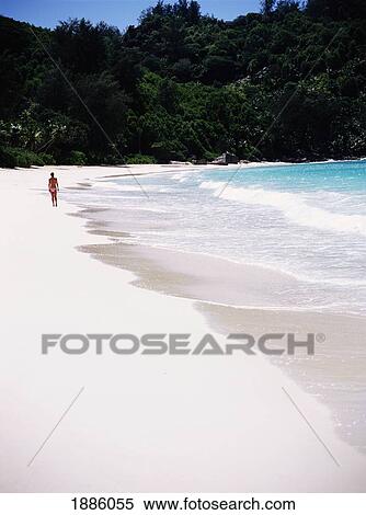 Stock Photography - Woman Walking On A Tropical Beach. Fotosearch